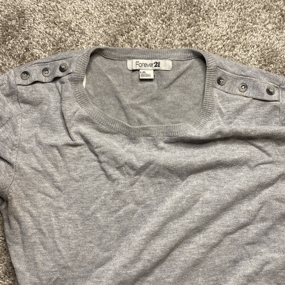 Grey sweater with bottom details on neckline